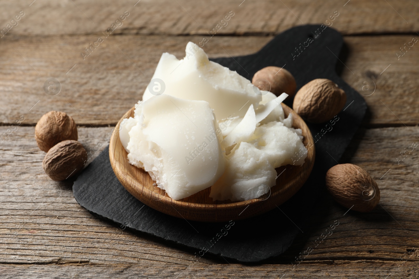 Photo of Natural shea butter and nuts on wooden table