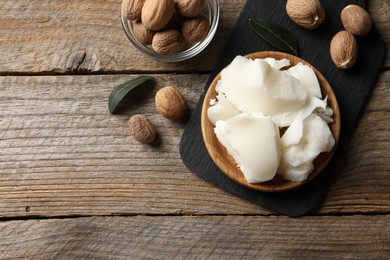 Photo of Natural shea butter and nuts on wooden table, top view. Space for text