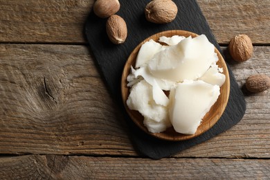 Photo of Natural shea butter and nuts on wooden table, top view. Space for text