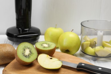 Photo of Hand blender kit and fresh fruits on white wooden table, closeup