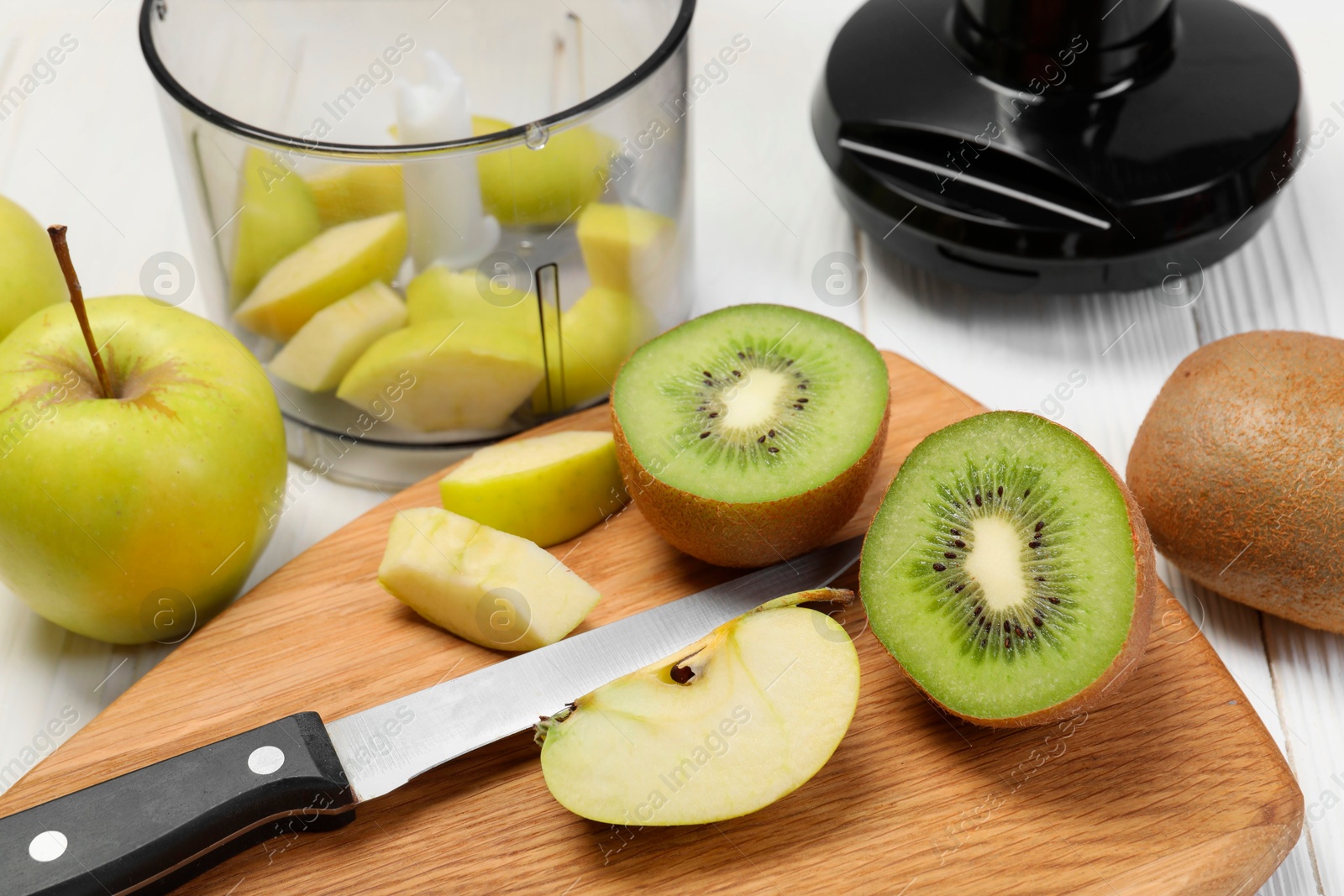 Photo of Hand blender kit and fresh fruits on white wooden table, closeup