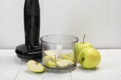 Photo of Hand blender kit and fresh apples on white wooden table