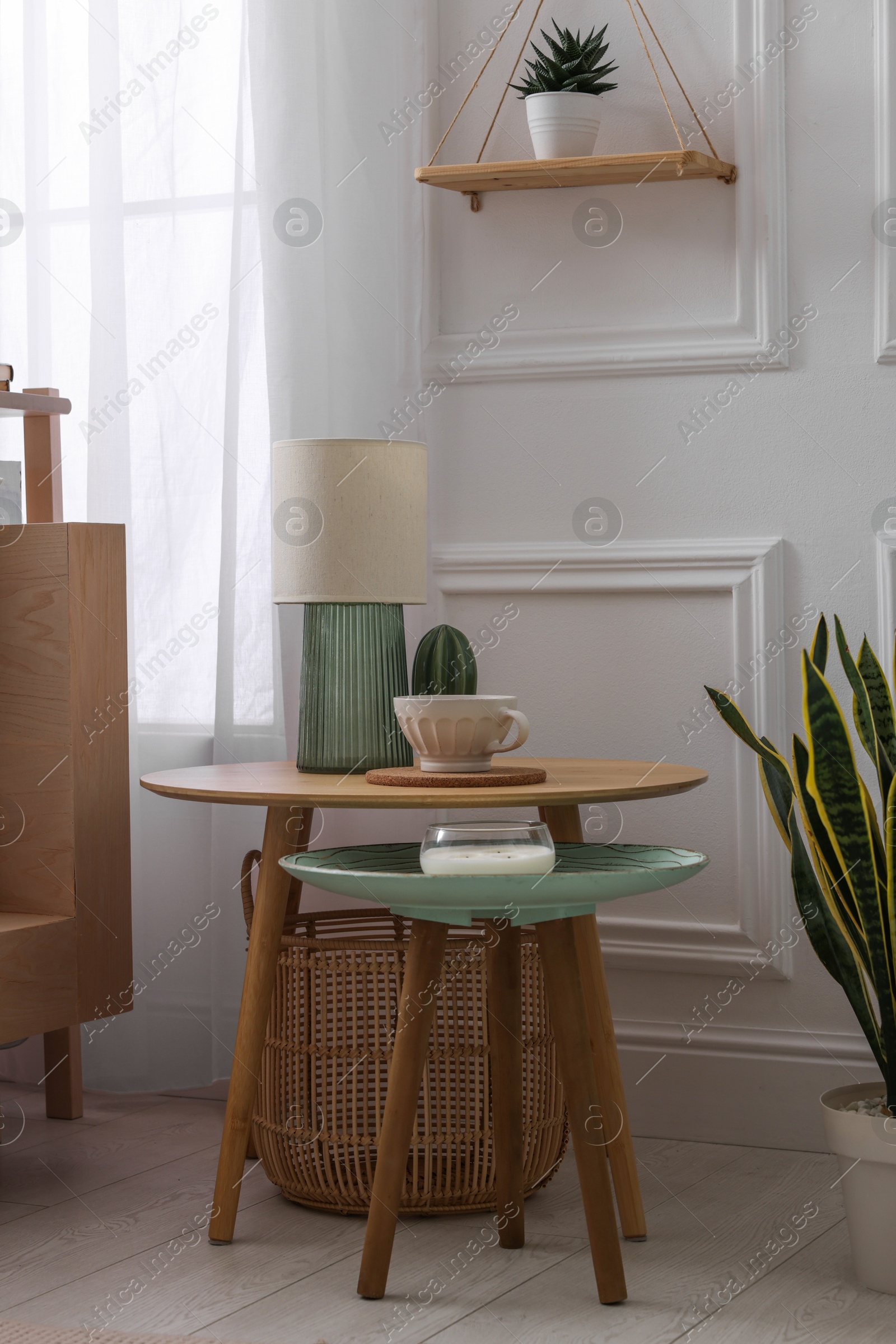 Photo of Stylish living room interior with bed, bedside tables, lamp and houseplants