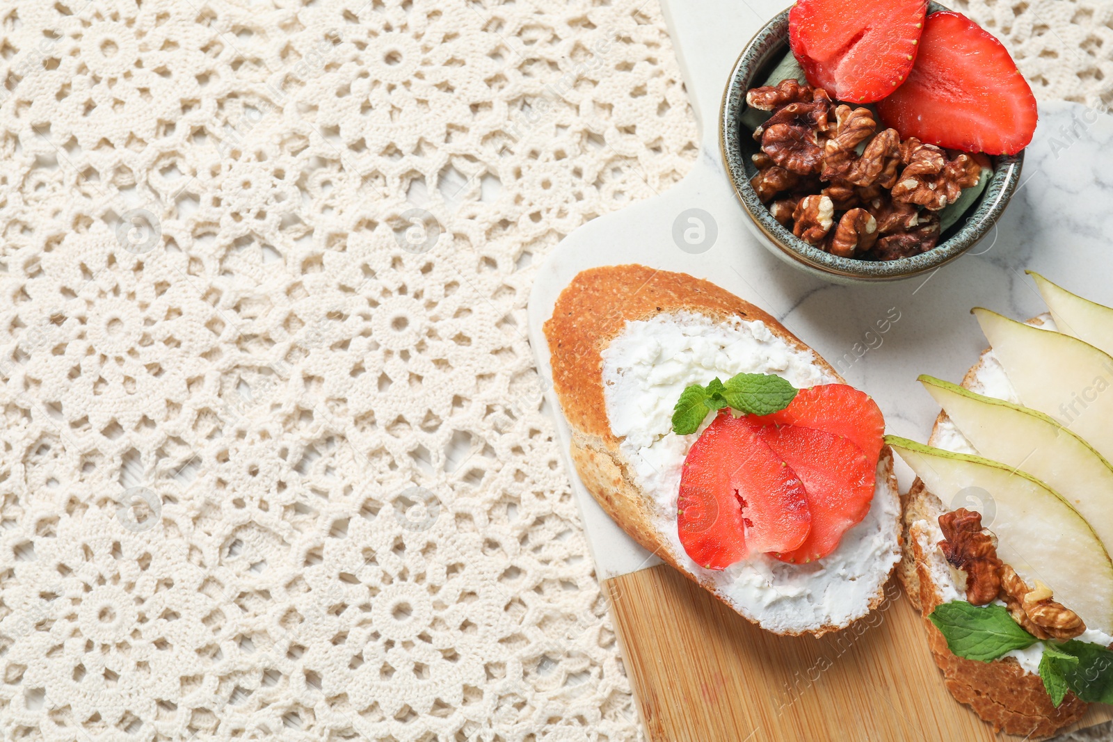 Photo of Delicious bruschettas with fresh ricotta (cream cheese), strawberry, mint and pear on table, flat lay. Space for text