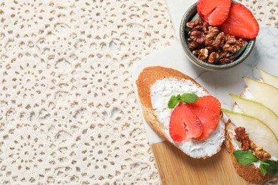 Delicious bruschettas with fresh ricotta (cream cheese), strawberry, mint and pear on table, flat lay. Space for text