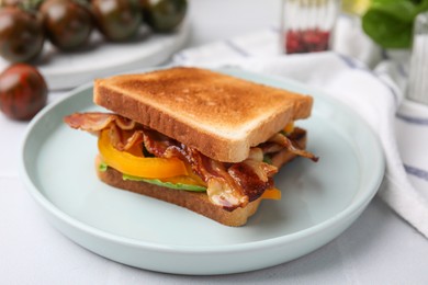 Photo of Tasty sandwich with bacon and bell pepper on white table, closeup