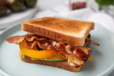 Photo of Tasty sandwich with bacon and bell pepper on white table, closeup