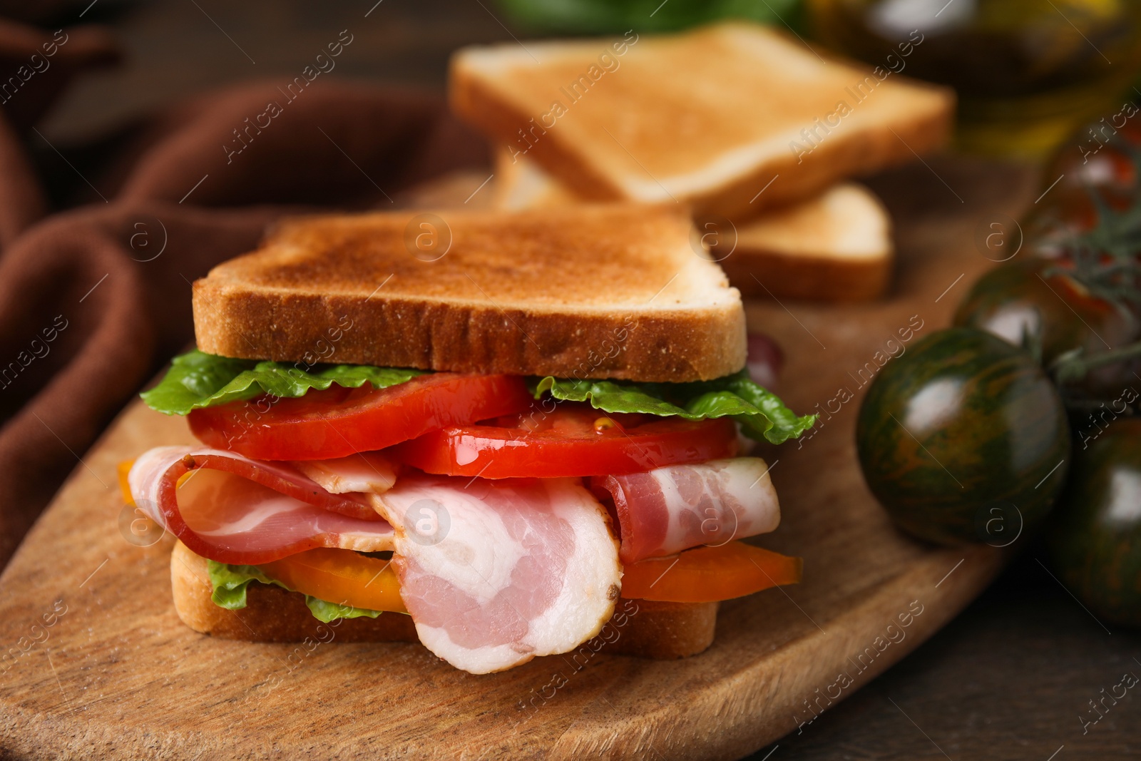 Photo of Tasty sandwich with bacon and tomato on table, closeup