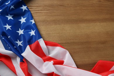 Photo of Flag of USA on wooden table, top view. Space for text