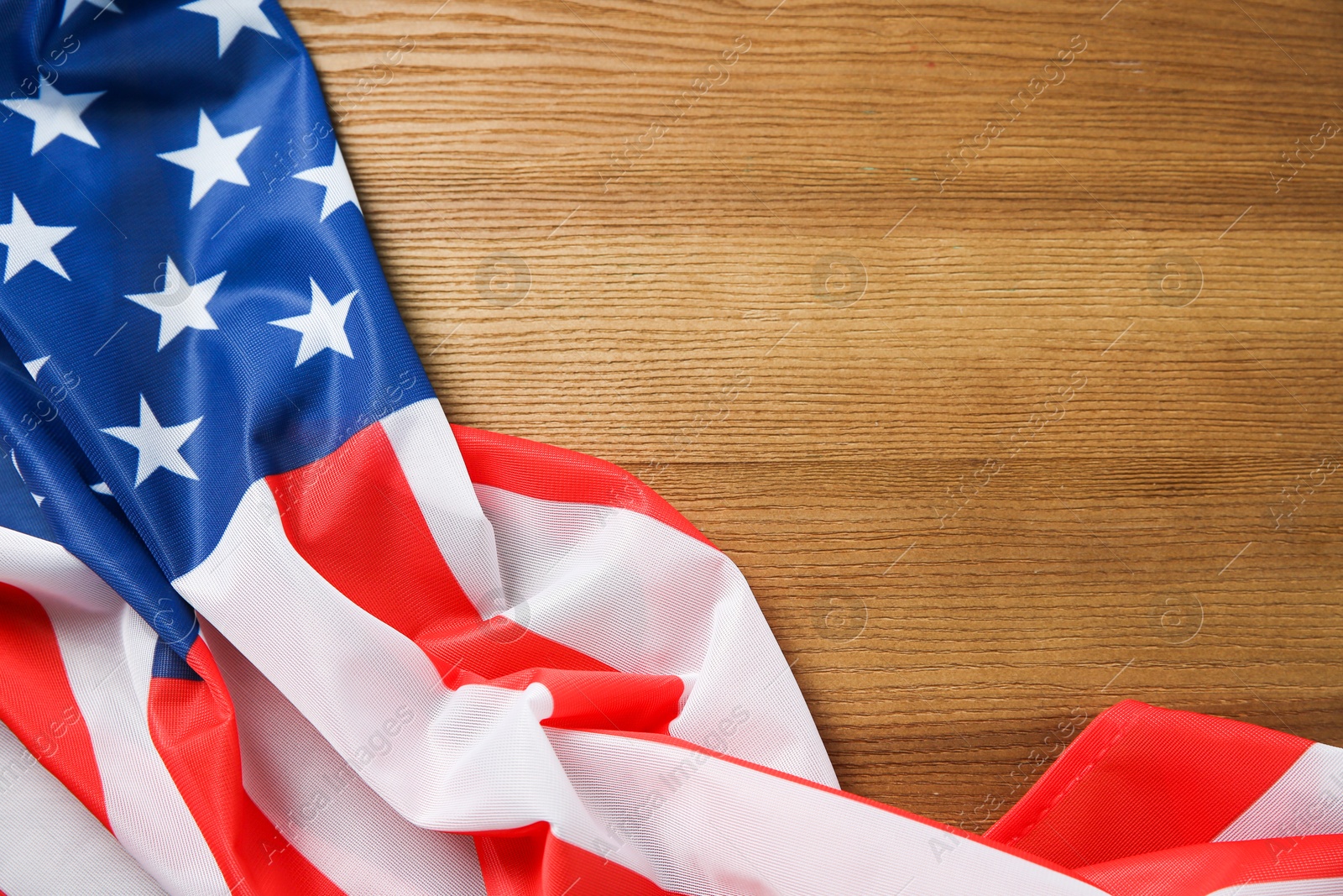 Photo of Flag of USA on wooden table, top view. Space for text