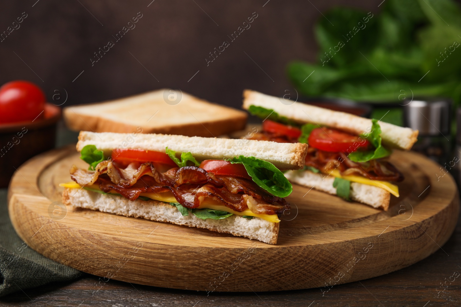 Photo of Delicious sandwiches with fried bacon on wooden table, closeup