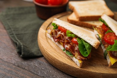 Photo of Delicious sandwiches with fried bacon on wooden table, closeup. Space for text