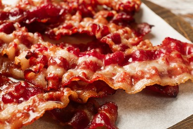 Photo of Slices of tasty fried bacon on table, closeup