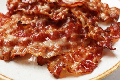 Photo of Slices of tasty fried bacon on table, closeup