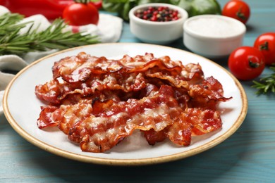 Photo of Slices of tasty fried bacon and different spices on light blue wooden table, closeup