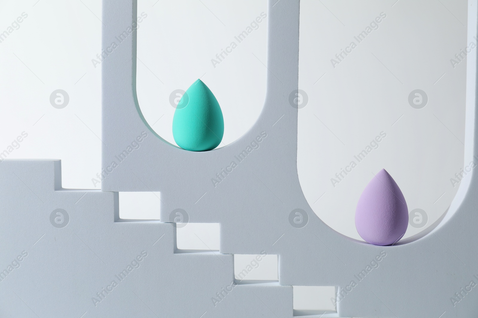 Photo of Stylish presentation of makeup sponges on white background