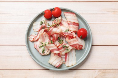 Slices of raw bacon, microgreens and tomatoes on wooden table, top view