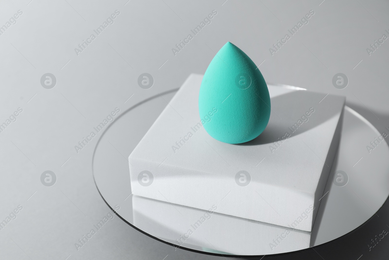 Photo of Stylish presentation of makeup sponge on light grey background. Space for text