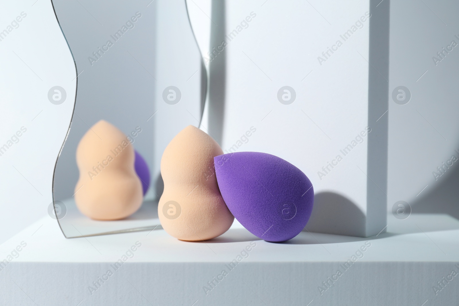 Photo of Stylish presentation of makeup sponges on light grey background