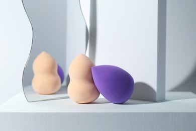 Photo of Stylish presentation of makeup sponges on light grey background