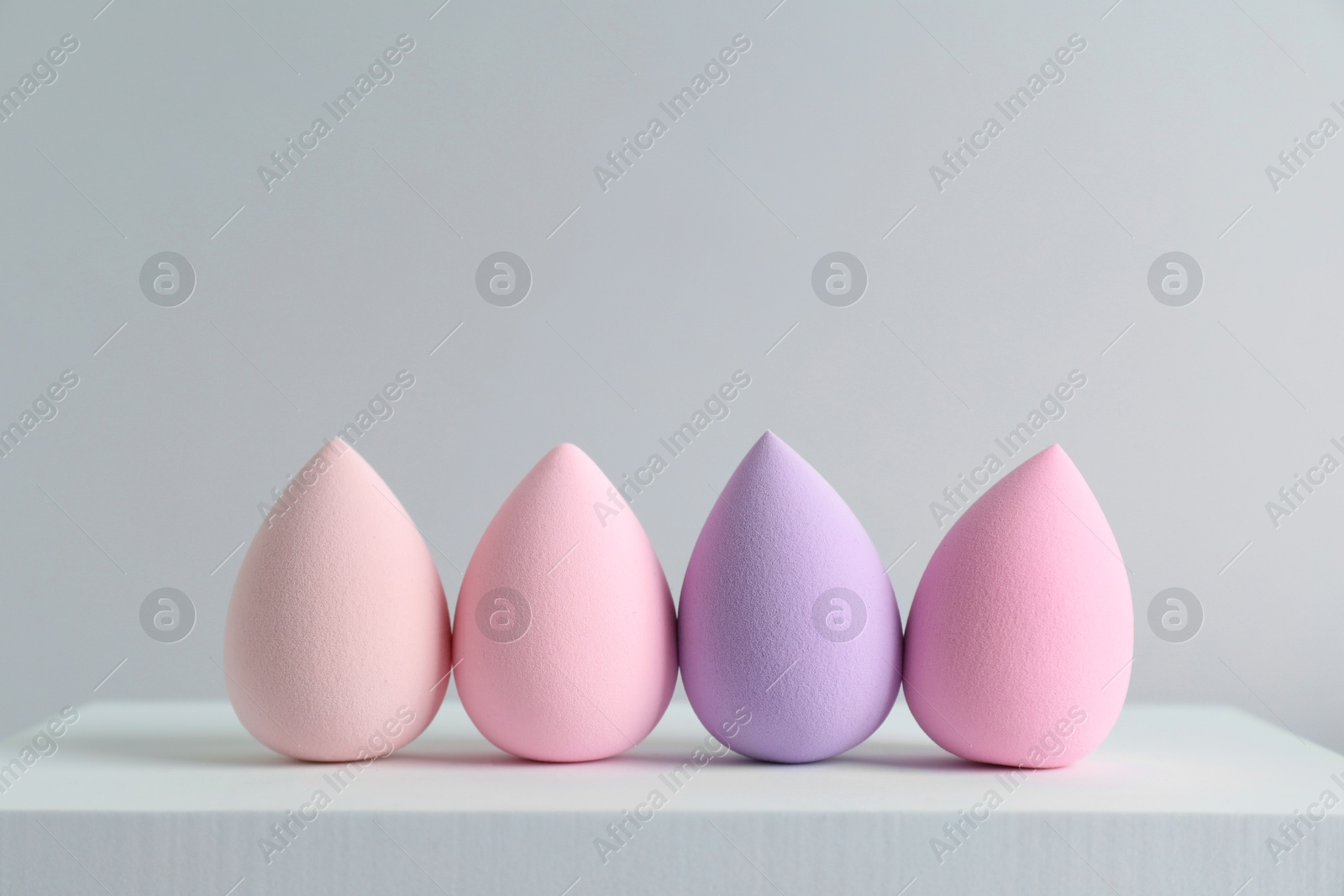 Photo of Stylish presentation of makeup sponges on light grey background