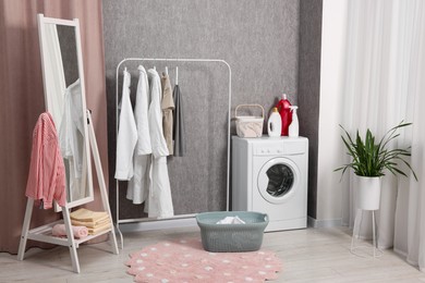 Washing machine, detergents, baskets, clothing rack and mirror indoors