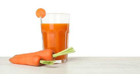 Photo of Fresh carrot juice in glass and vegetables on wooden table against white background. Space for text