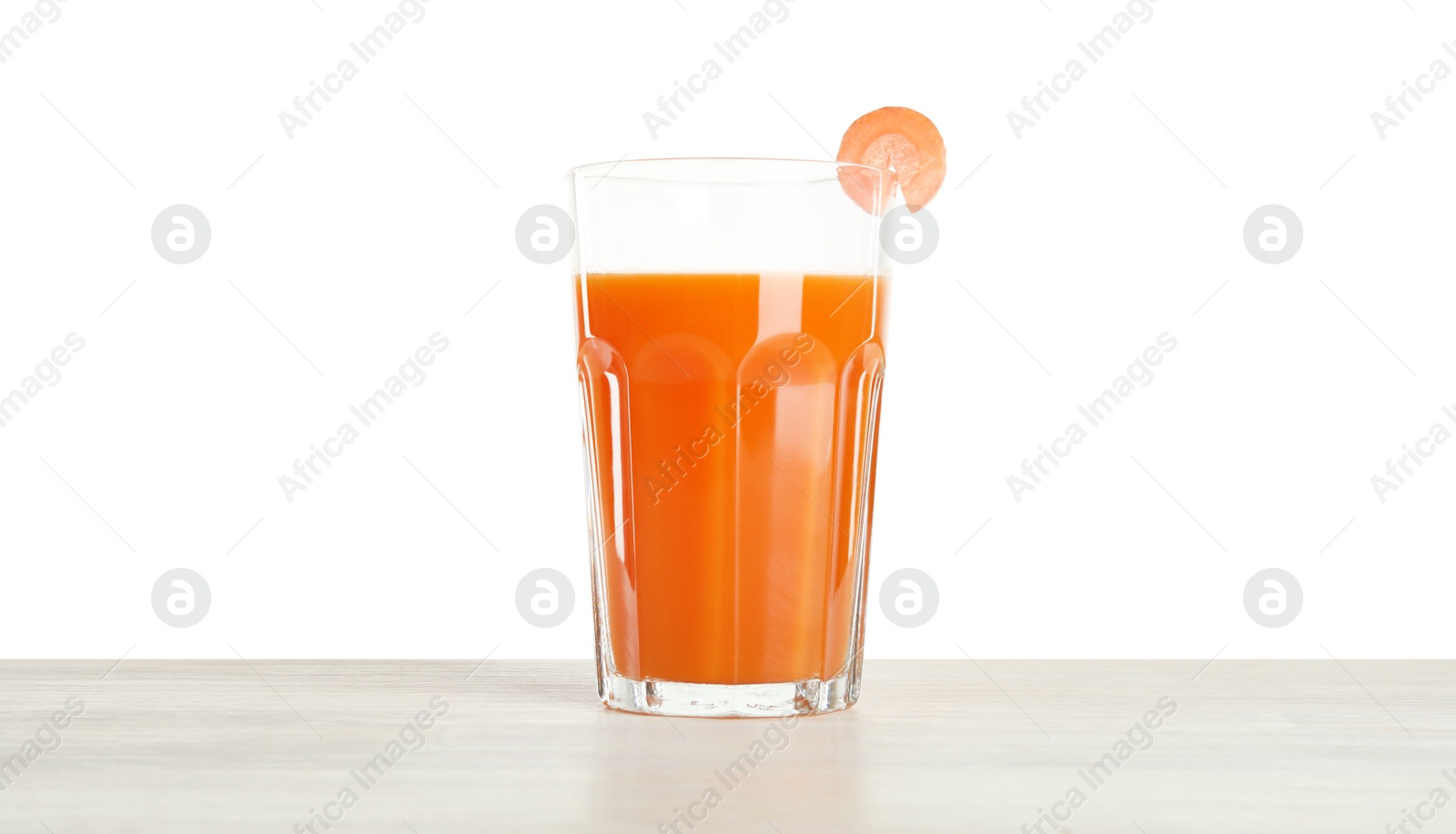 Photo of Fresh carrot juice in glass on wooden table against white background