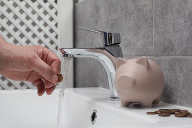 Photo of Water saving concept. Woman with coin under tap water in bathroom