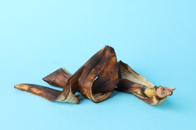 Banana peel with dark spots on light blue background