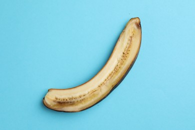 Photo of Half of overripe banana on light blue background, top view