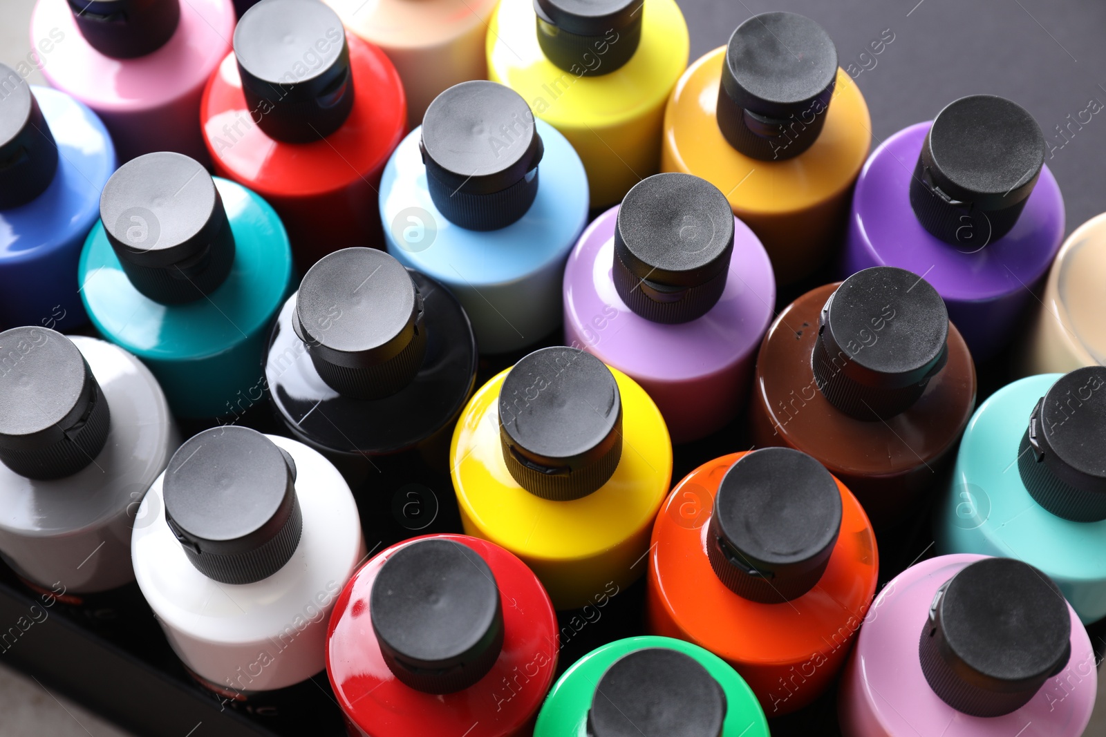 Photo of Acrylic paints of different colors in bottles on table, above view