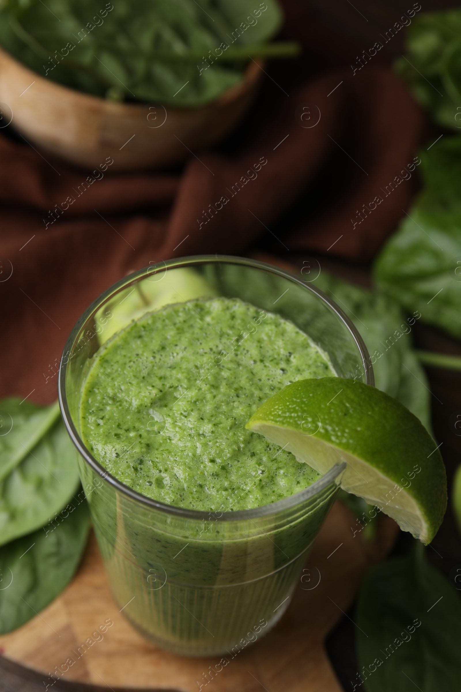 Photo of Tasty green smoothie in glass with lime on table, above view