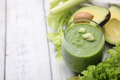 Tasty green smoothie in glass and products on wooden rustic table, closeup. Space for text