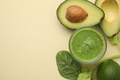 Photo of Tasty green smoothie in glass and products on beige background, flat lay. Space for text