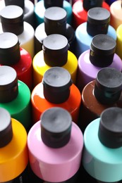 Acrylic paints of different colors in bottles, closeup