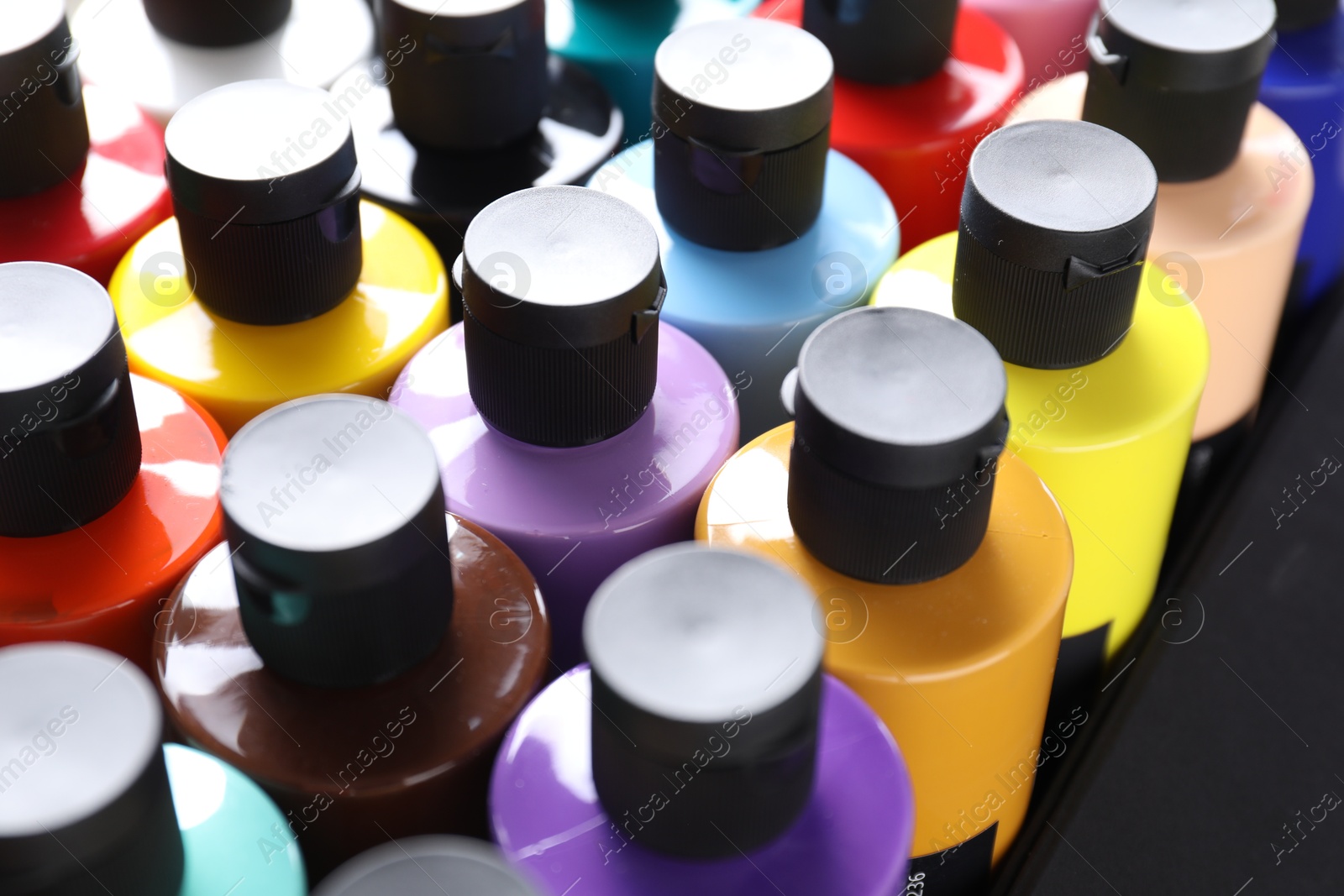 Photo of Acrylic paints of different colors in bottles, closeup