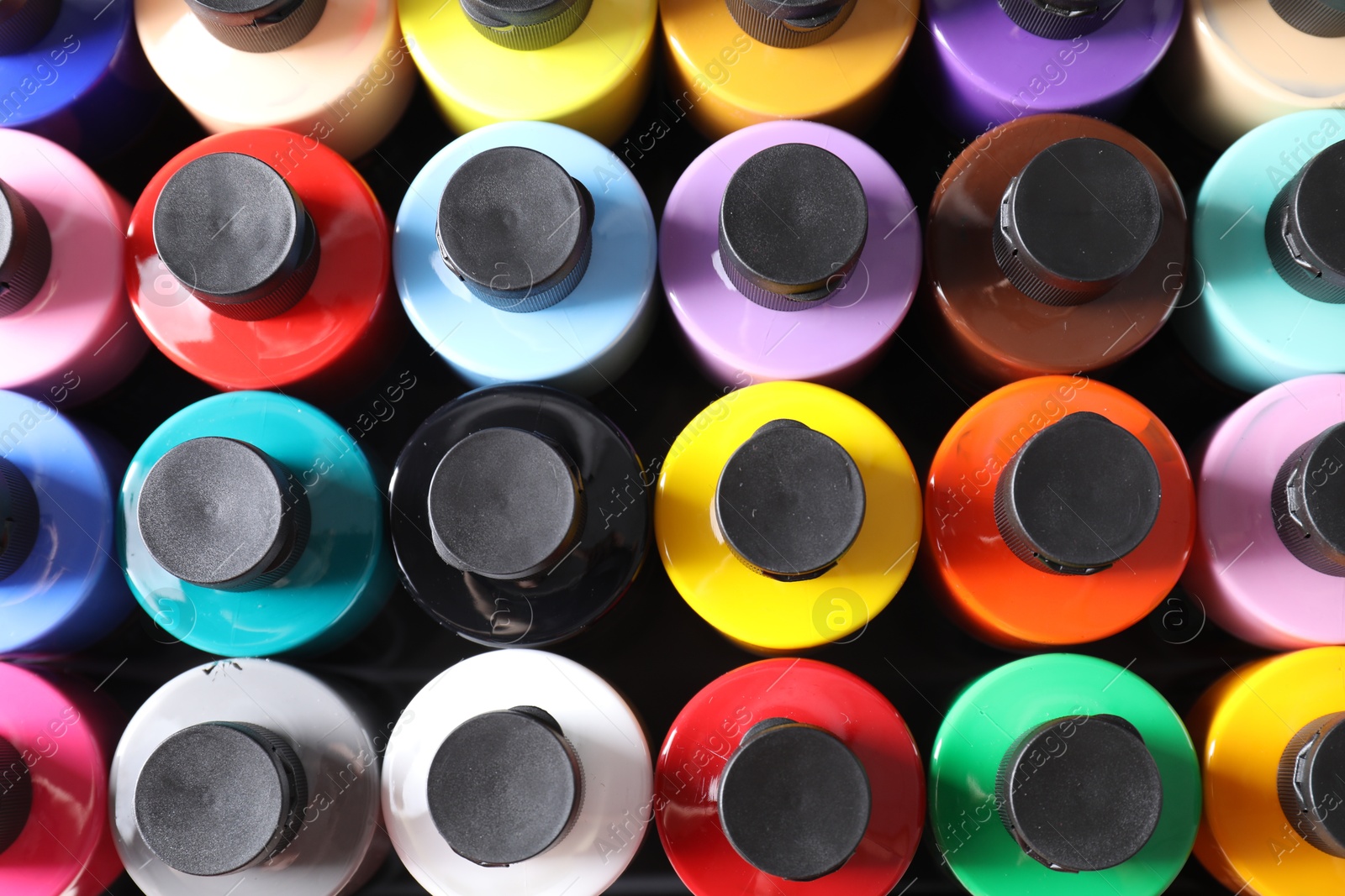 Photo of Acrylic paints of different colors in bottles on table, top view