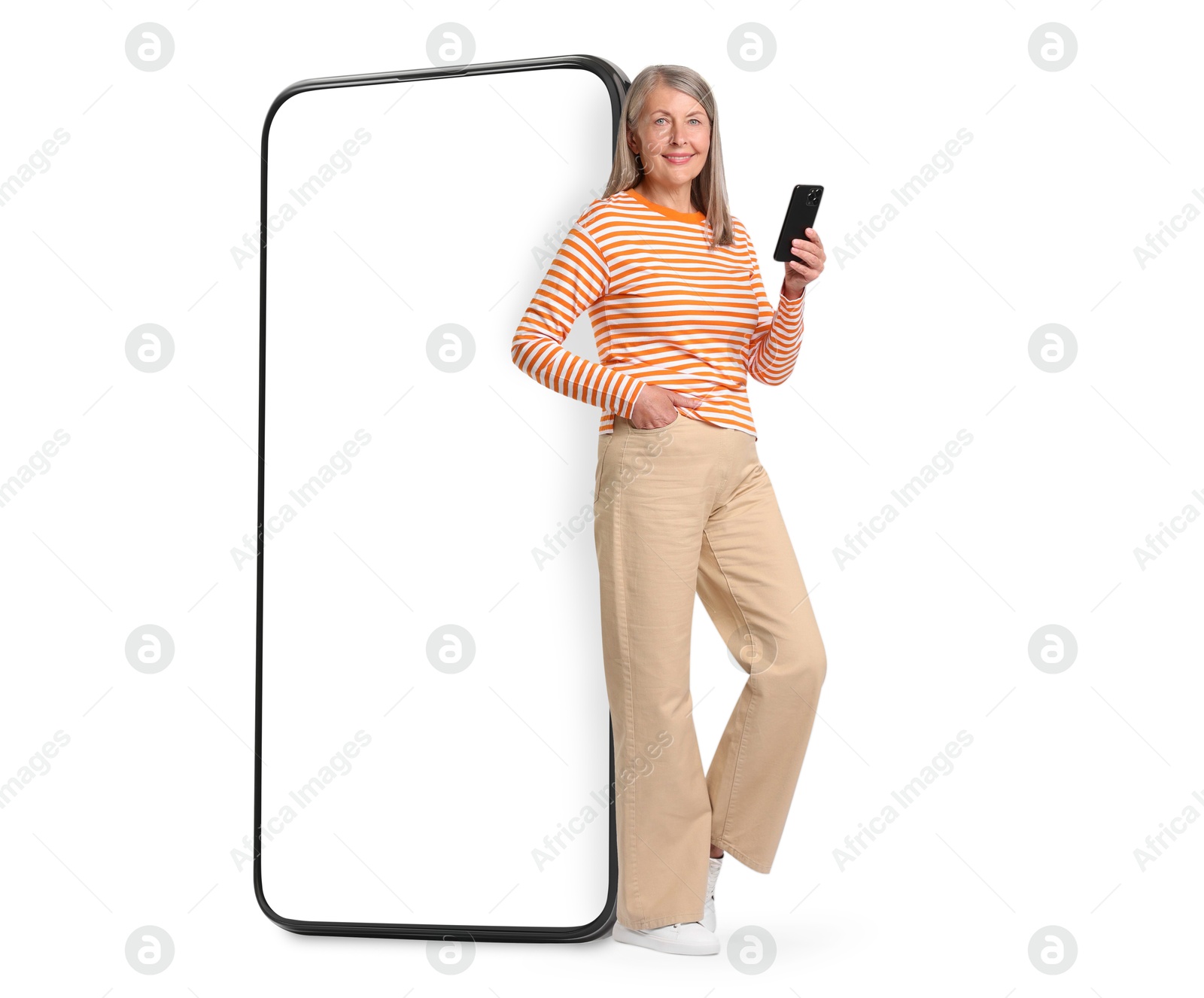 Image of Happy mature woman holding mobile phone near big smartphone on white background