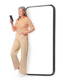 Happy mature woman holding mobile phone near big smartphone on white background