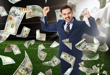 Image of Happy man under money shower at stadium