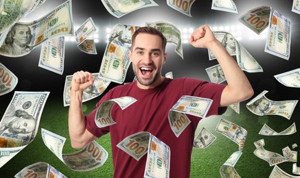 Happy man under money shower at stadium