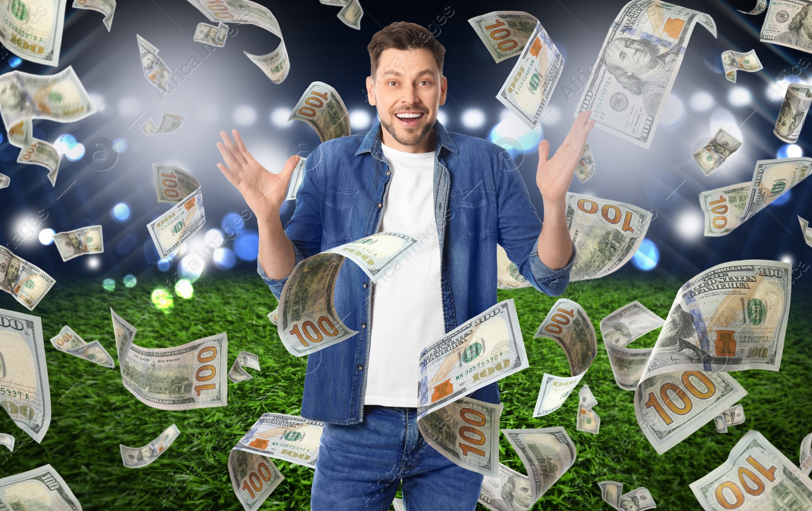 Image of Happy man under money shower at stadium