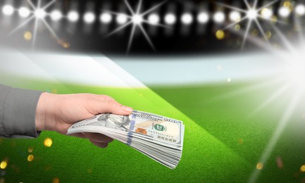 Image of Man holding money at stadium, closeup. Space for text