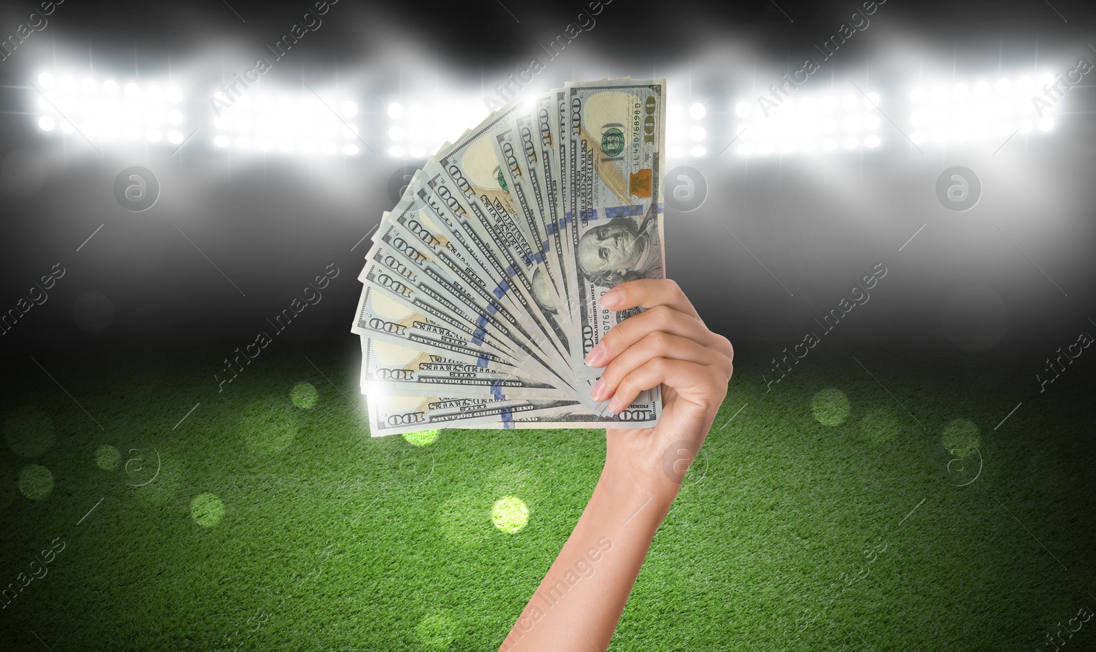 Image of Woman holding dollar bills at stadium, closeup