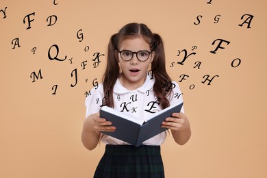 Surprised girl with book on dark beige background. Letters flying out of book