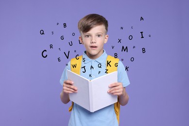 Surprised boy with book and backpack on blue violet background. Letters flying out of book