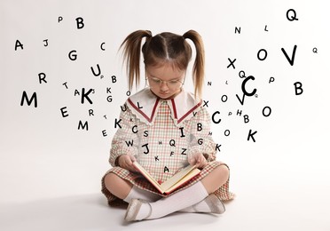 Girl with glasses reading book on white background. Letters flying out of book