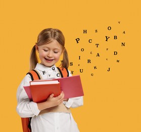 Girl reading book on orange background. Letters flying out of book