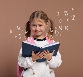 Image of Smiling girl with book on brown background. Letters flying out of book